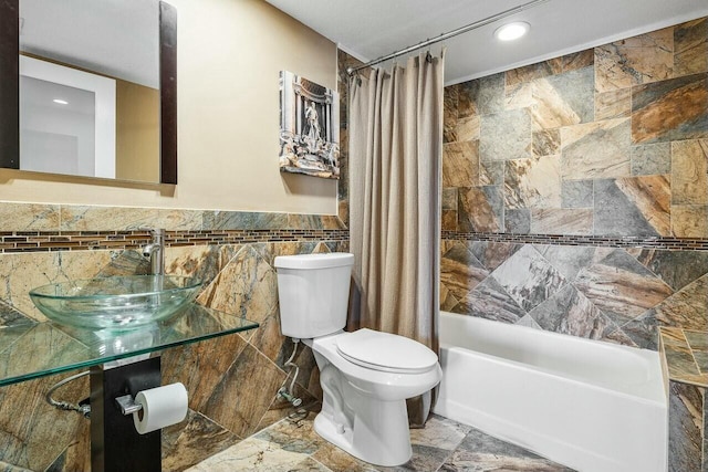 full bathroom with shower / bath combination with curtain, toilet, tile walls, and sink