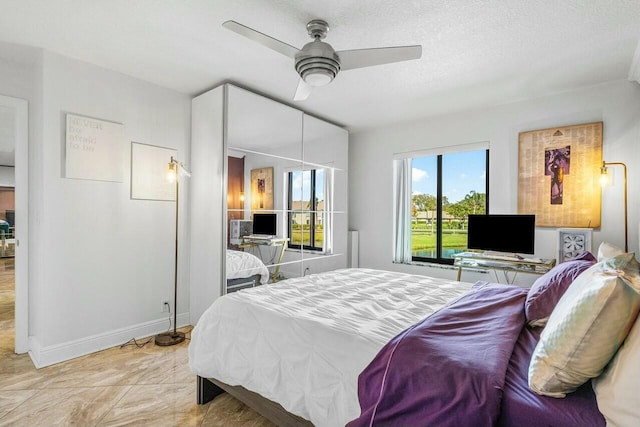 bedroom with a textured ceiling, ceiling fan, and light tile patterned flooring