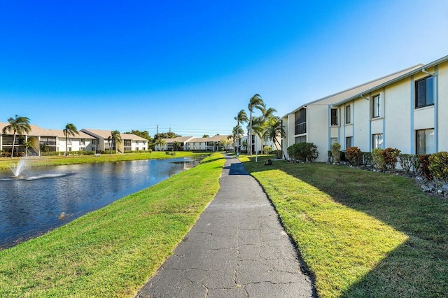 surrounding community with a lawn and a water view