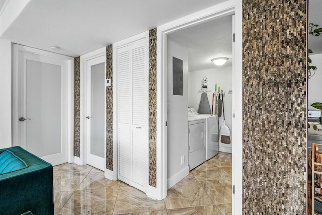 washroom featuring electric panel, washer and clothes dryer, and a textured ceiling