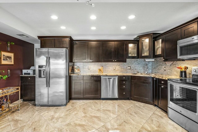 kitchen featuring dark brown cabinetry, light stone countertops, and appliances with stainless steel finishes