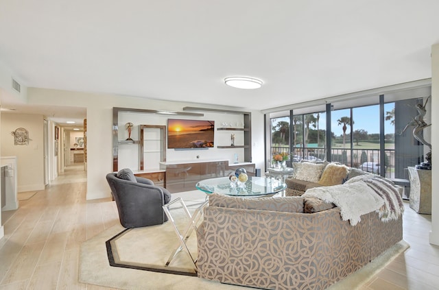 living room with light hardwood / wood-style floors and floor to ceiling windows