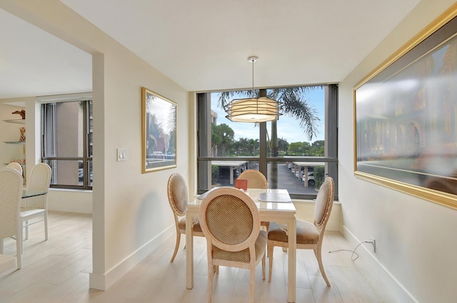 20100 Boca W Dr Unit 125, Boca Raton, FL 33434 - dining room with baseboards, light wood-style flooring, and a wall of windows