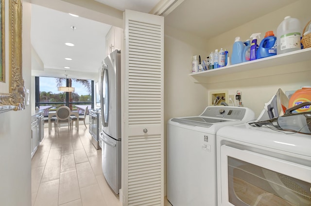 laundry room featuring washer and clothes dryer and light hardwood / wood-style floors