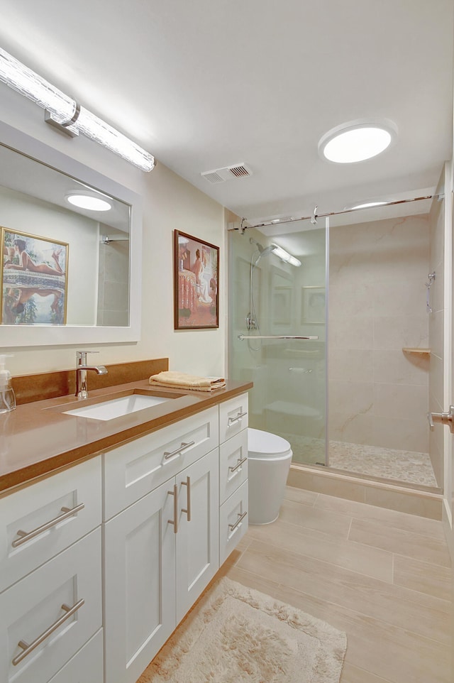 bathroom featuring vanity, toilet, and walk in shower