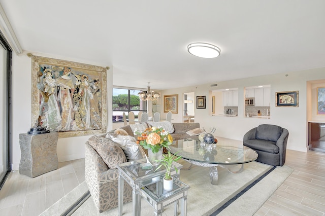 living room with a chandelier and light wood-type flooring