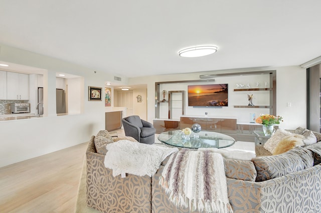 living room featuring light hardwood / wood-style flooring and sink