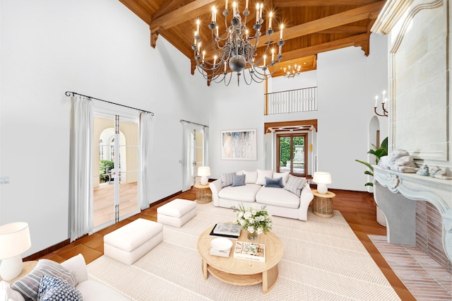 living room with high vaulted ceiling, beamed ceiling, a chandelier, and wooden ceiling