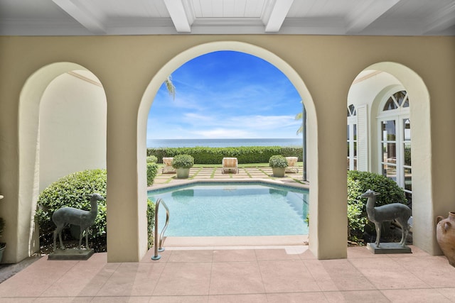 view of swimming pool featuring a water view and a patio area