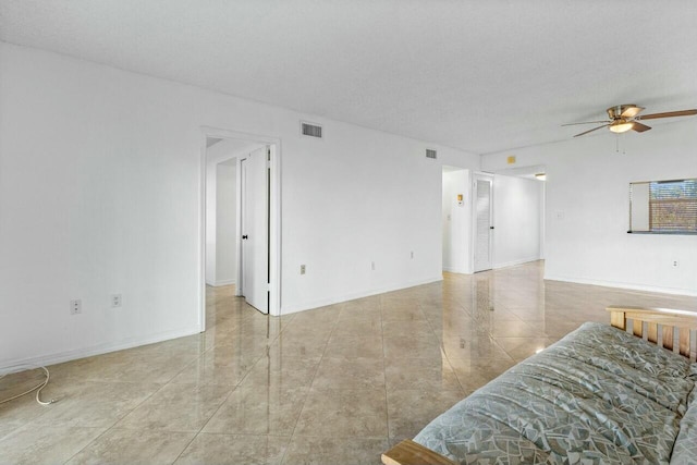 living room featuring ceiling fan and a textured ceiling