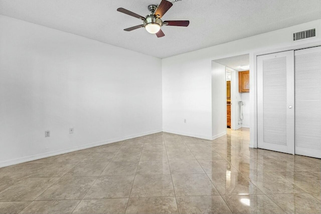 spare room featuring ceiling fan and a textured ceiling