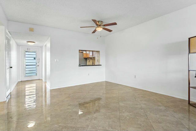 empty room featuring ceiling fan and a textured ceiling