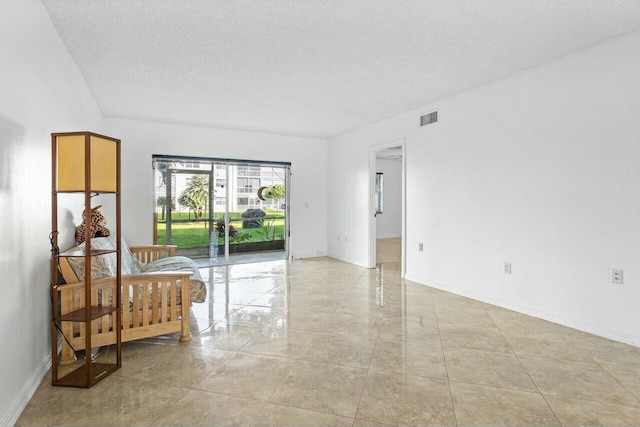 unfurnished room with a textured ceiling