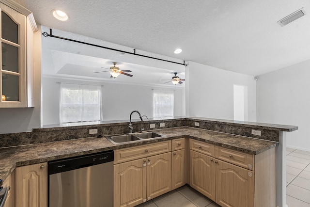 kitchen featuring dishwasher, sink, light tile patterned floors, a textured ceiling, and kitchen peninsula