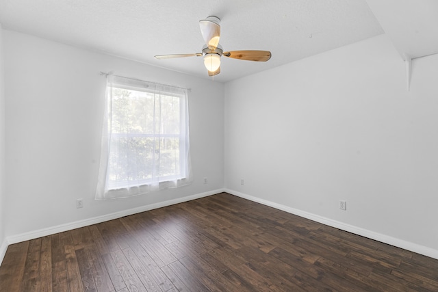 empty room with ceiling fan and dark wood-type flooring