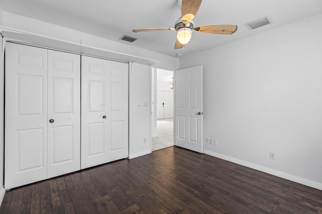 unfurnished bedroom featuring ceiling fan, dark hardwood / wood-style flooring, and a closet