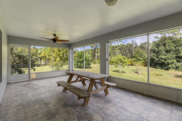 unfurnished sunroom featuring ceiling fan