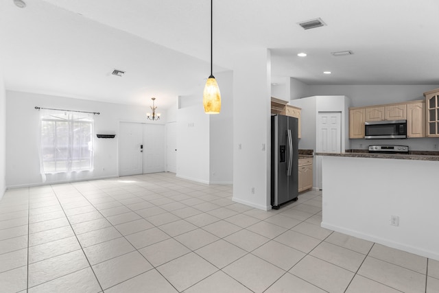 kitchen featuring light brown cabinets, hanging light fixtures, a chandelier, lofted ceiling, and appliances with stainless steel finishes