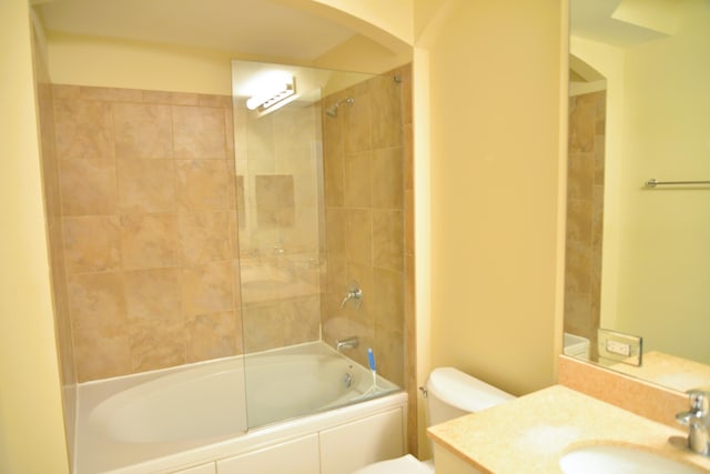 full bathroom with vanity, tiled shower / bath combo, and toilet