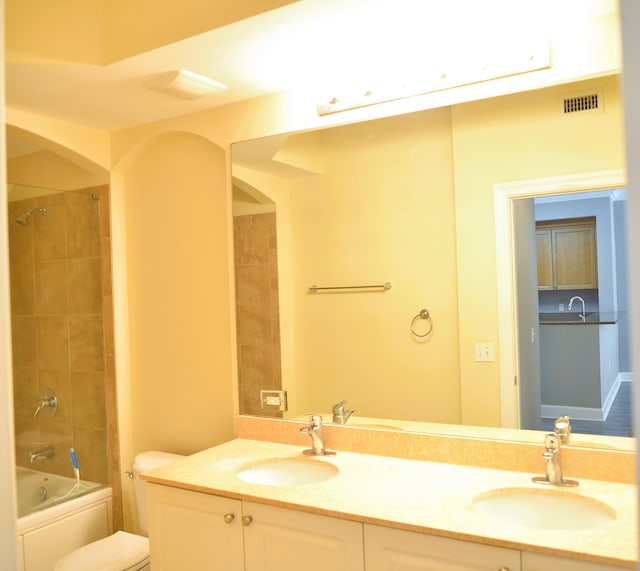 full bathroom with vanity, toilet, and tiled shower / bath combo