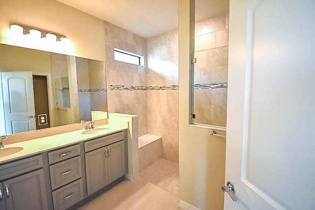 bathroom featuring tile patterned flooring, vanity, and tiled shower