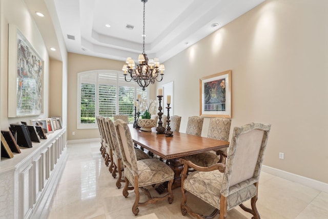 dining space with a tray ceiling and an inviting chandelier