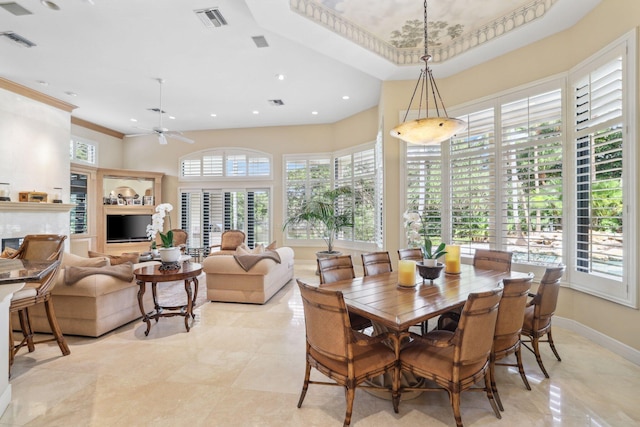 dining room featuring a high end fireplace, ceiling fan, and ornamental molding