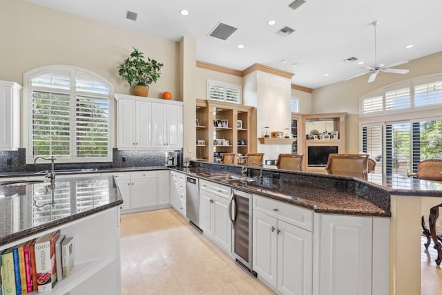 kitchen with white cabinets, a breakfast bar, backsplash, and beverage cooler