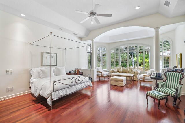 bedroom featuring ceiling fan, ornate columns, dark wood-type flooring, and vaulted ceiling