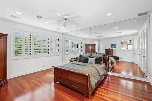 bedroom with dark hardwood / wood-style floors, multiple windows, and ceiling fan