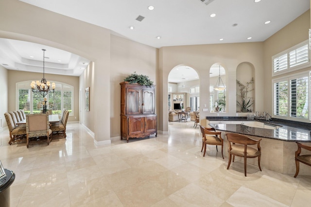 dining area with a chandelier, a high ceiling, and sink