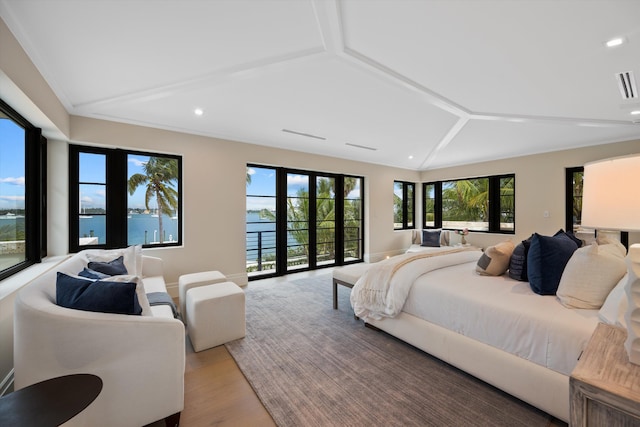 bedroom with lofted ceiling with beams, light wood-type flooring, a water view, and french doors