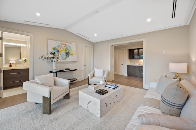 living room with light hardwood / wood-style floors and vaulted ceiling