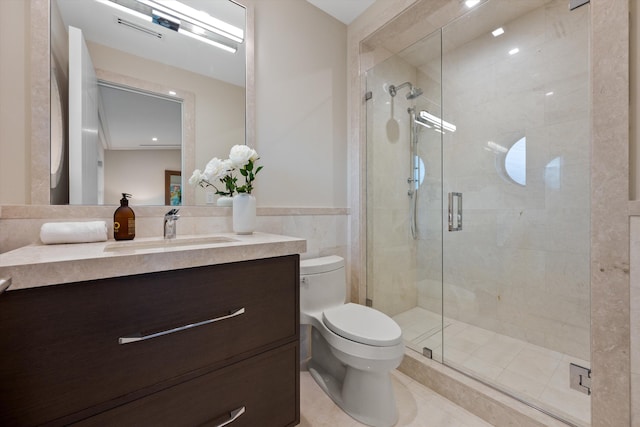 bathroom with tile walls, tile patterned floors, walk in shower, vanity, and toilet