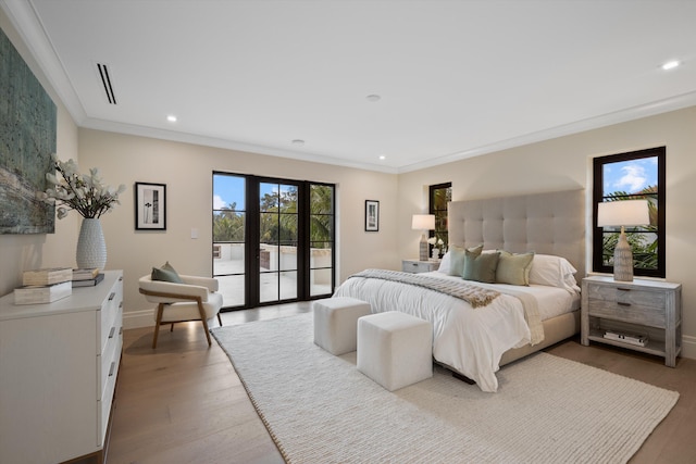 bedroom featuring ornamental molding, access to outside, wood-type flooring, and french doors