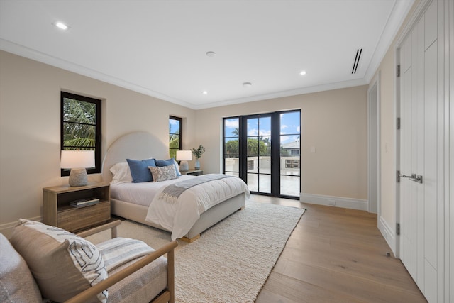 bedroom featuring access to outside, french doors, light hardwood / wood-style floors, and crown molding