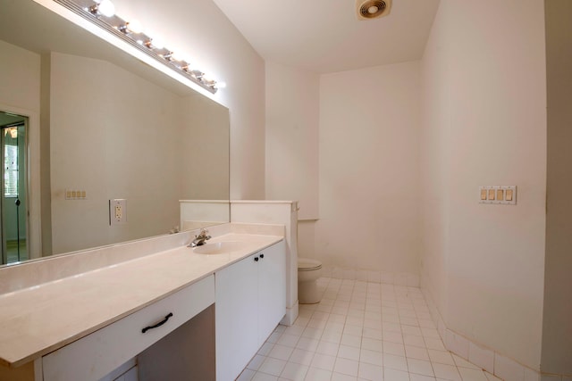 bathroom with toilet, vanity, and tile patterned floors