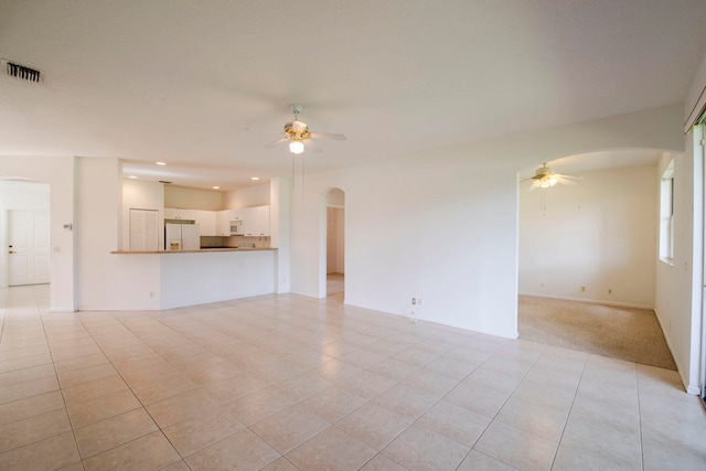 unfurnished living room with light tile patterned floors and ceiling fan