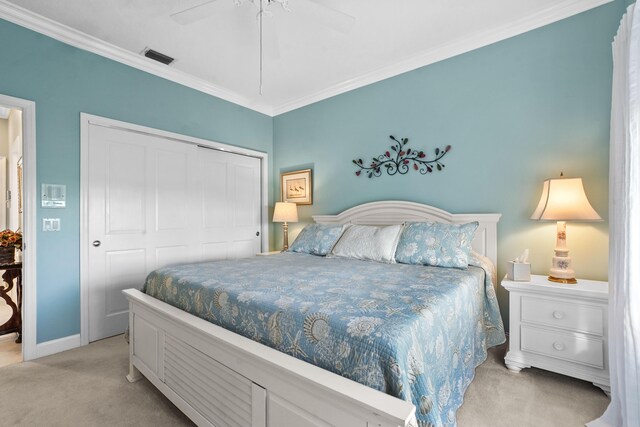 carpeted bedroom with ceiling fan, a closet, and crown molding