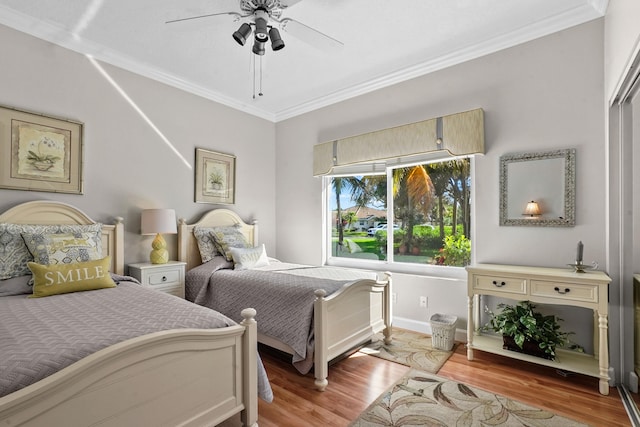 bedroom featuring light hardwood / wood-style floors, ceiling fan, and crown molding