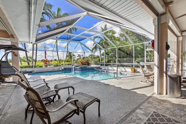 view of swimming pool featuring a pool with connected hot tub, glass enclosure, and a patio