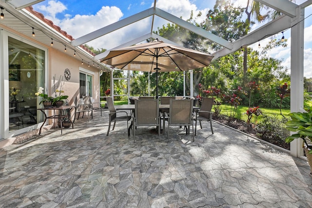 view of patio / terrace featuring glass enclosure and outdoor dining space