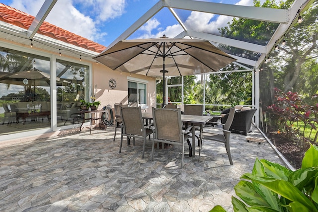 view of patio featuring glass enclosure and outdoor dining area