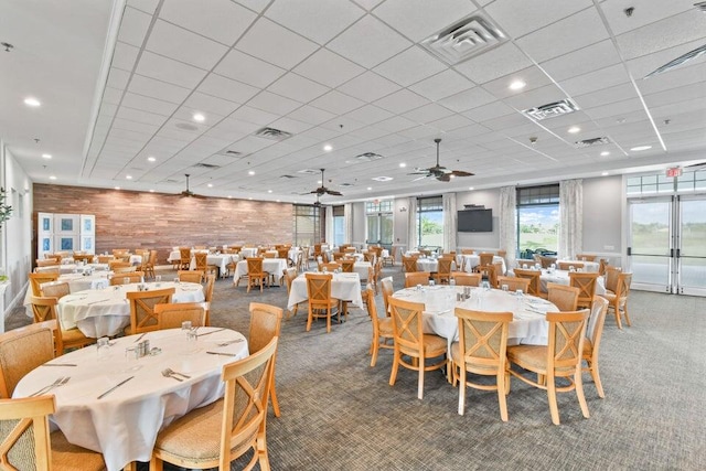 dining space featuring carpet, visible vents, and wooden walls