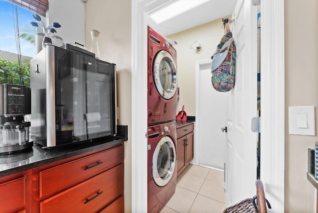 laundry room featuring light tile patterned floors and stacked washer and clothes dryer