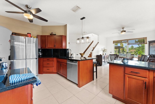 kitchen with decorative light fixtures, ceiling fan, sink, and appliances with stainless steel finishes