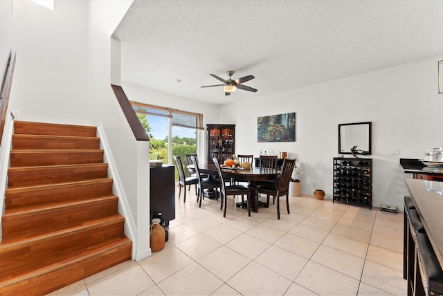 tiled dining room featuring ceiling fan, a textured ceiling, and beverage cooler