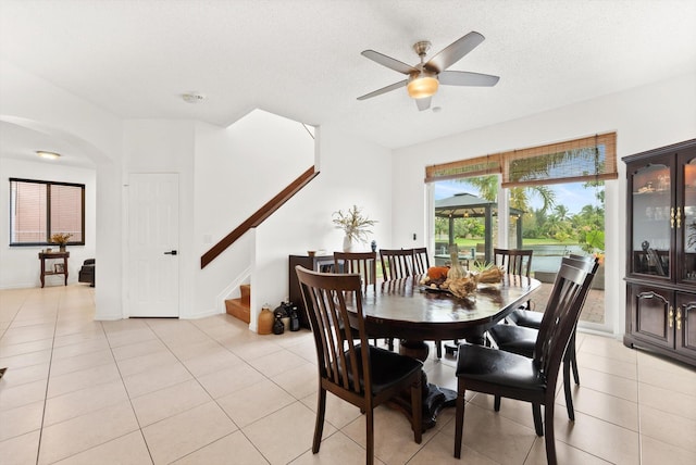 tiled dining room with ceiling fan and a textured ceiling