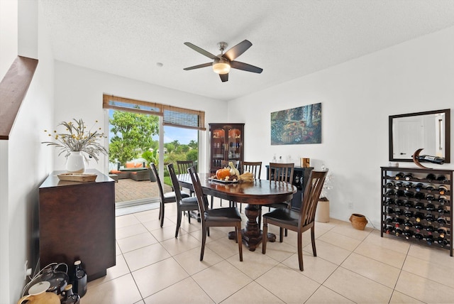 tiled dining room featuring ceiling fan and a textured ceiling