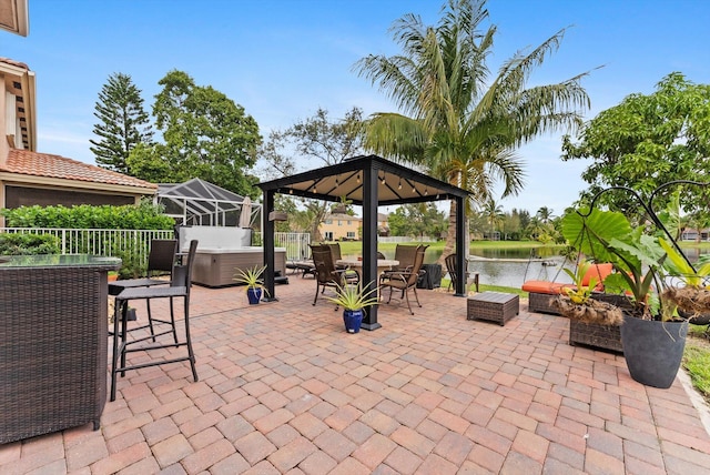 view of patio featuring a gazebo, glass enclosure, and a water view